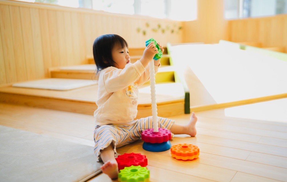 乳幼児スペースでおもちゃを重ねて遊ぶ子ども